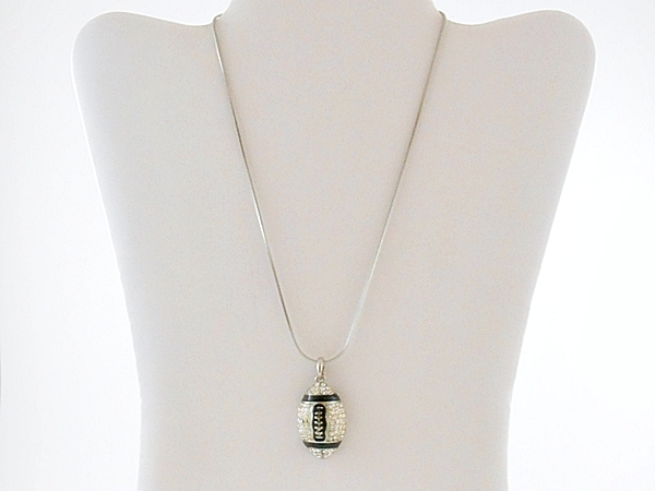 Crystal studded rhinestone football pendant necklace on silver chain.