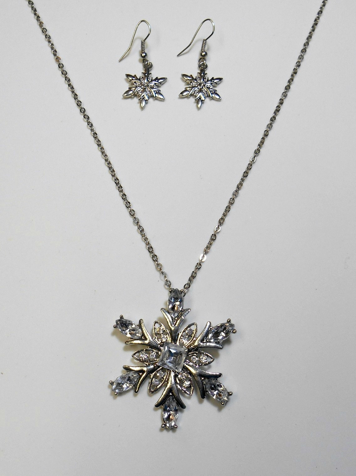 Silver snowflake rhinestone necklace with matching silver snowflake earrings.