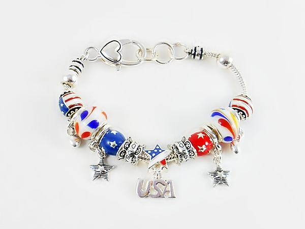 Silver snake chain charm bracelet with patriotic charm beads in red, white, blue and gold including dangle beads, large and small glass beads, and spacer beads.