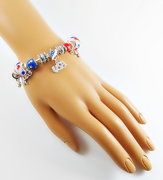 Silver snake chain charm bracelet with patriotic charm beads in red, white, blue and gold including dangle beads, large and small glass beads, and spacer beads.