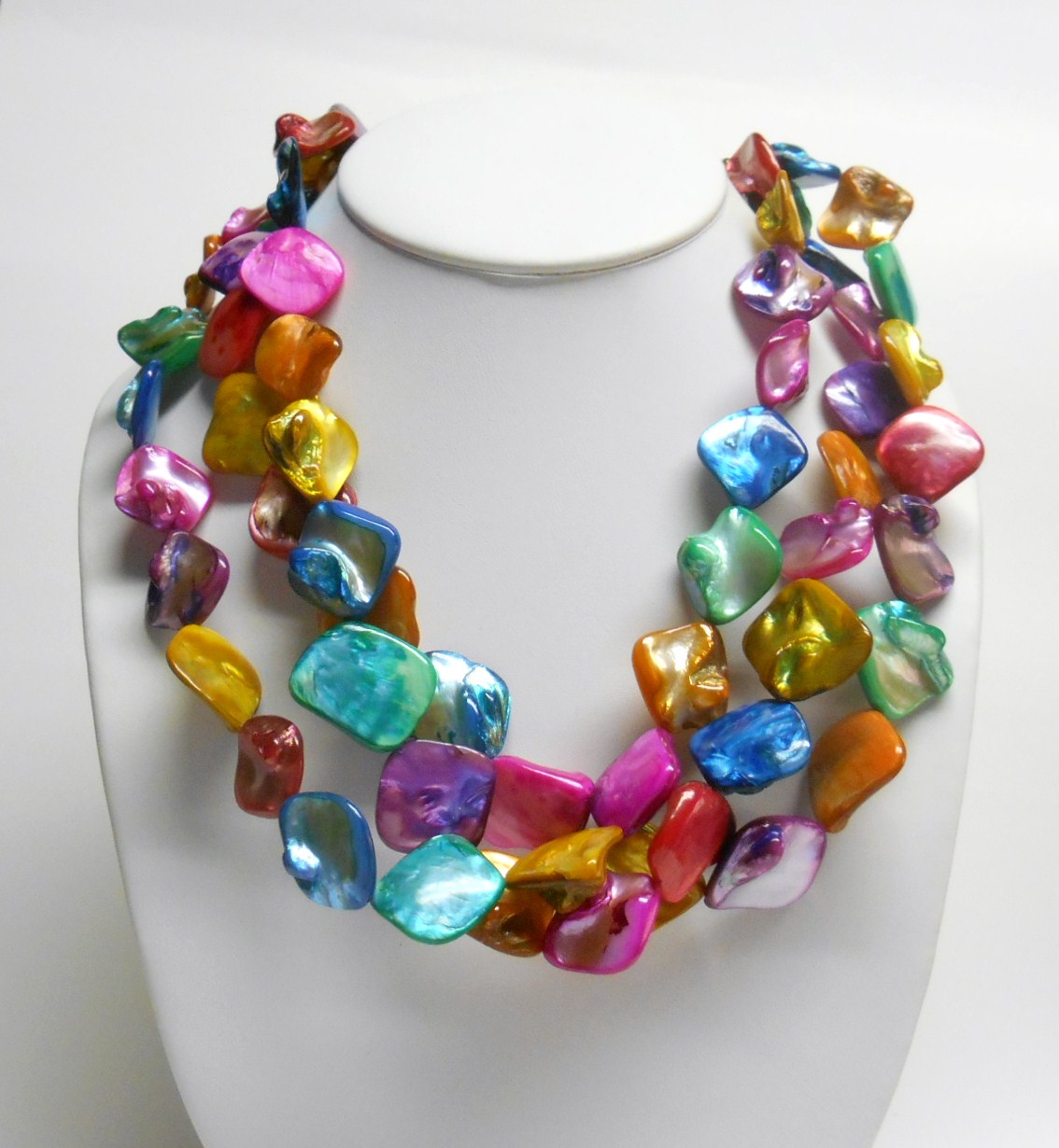 Three strands of vibrant rainbow multi color shells make up this unique necklace. The matching hook dangle earrings are made of the same pink and blue shells.