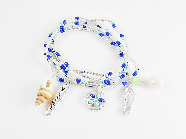 Set of 5 stretch bracelets with turquoise, blue and iridescent seed beads, silver tube beads and beach themed charms including a sand dollar, flip flop, sea shell, pearl bead, and beach girl.