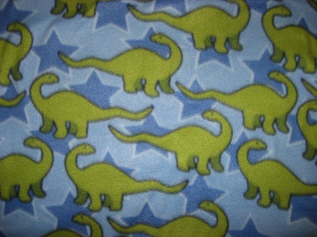 Green dinosaurs and stars on a blue child bed size fleece blanket