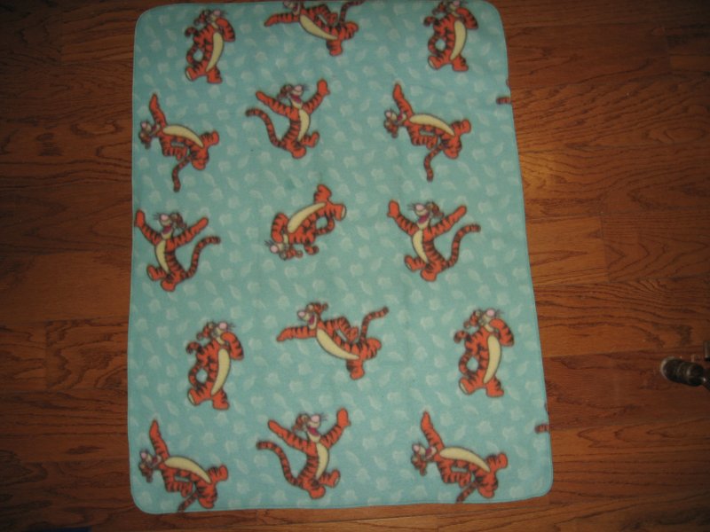 Image 1 of Tigger jumping around on a bluegreen soft  fleece baby blanket