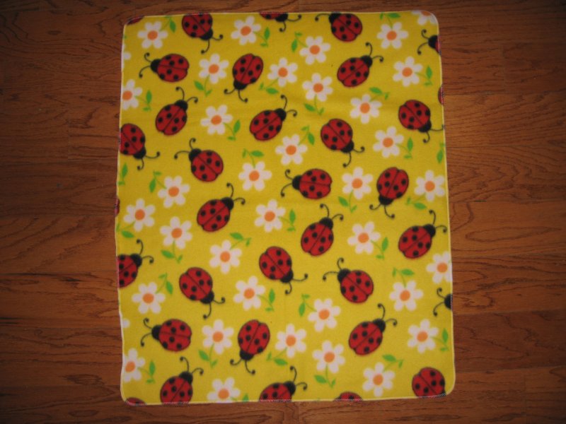 Image 1 of Lady Bug red insect daisy flower on a yellow baby fleece blanket