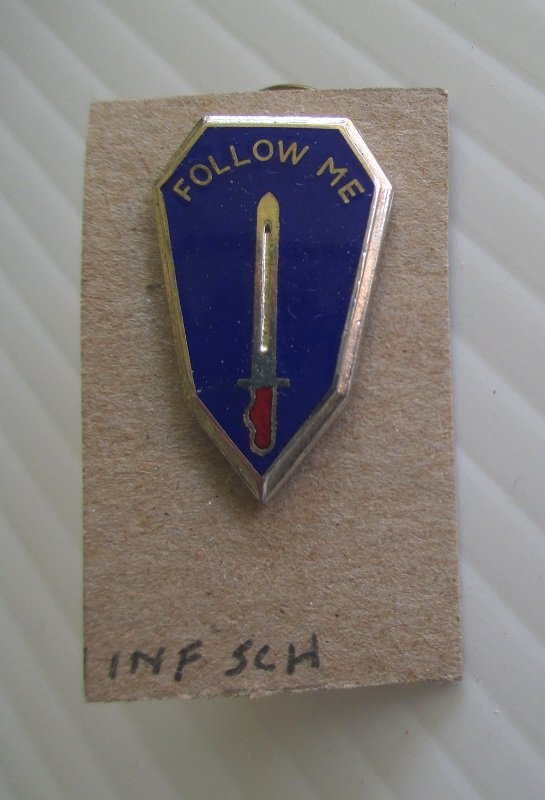 Army Infantry School insignia metal pin. Features a sword and the words Follow Me. DUI. Excellent condition. G23