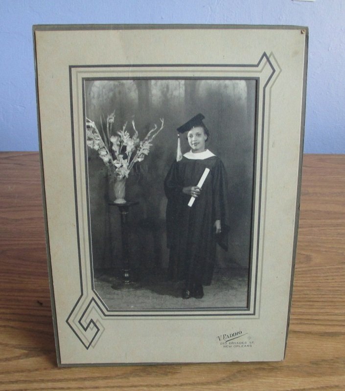 Photo of a Black African American woman graduate in cap and gown with diploma. Circa 1930s New Orleans Louisiana. 