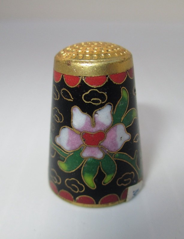 Decorative gold tone cloisonne enamel thimble. Base color of black with multi color flowers. One inch tall. Stated Made in Beijing China.