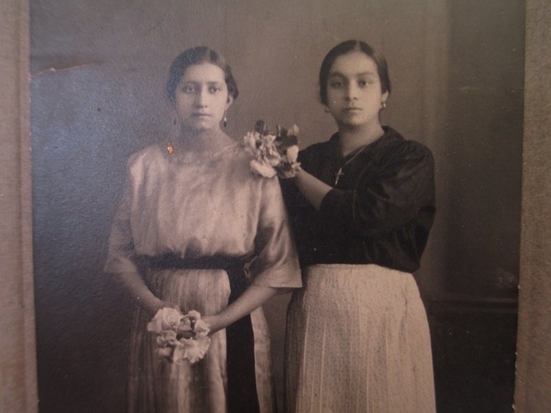 Circa 1910 antique photo of 2 hispanic women, each holding a bouquet of flowers. Unknown location. Possible name of Zendejas.