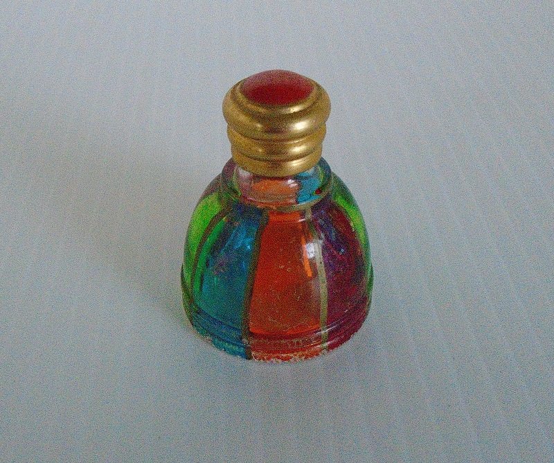 Empty rainbow or multi colored mini perfume bottle. Stands just under 2 inches tall. No markings. Vintage to 1970s or before. Free of any aroma. 