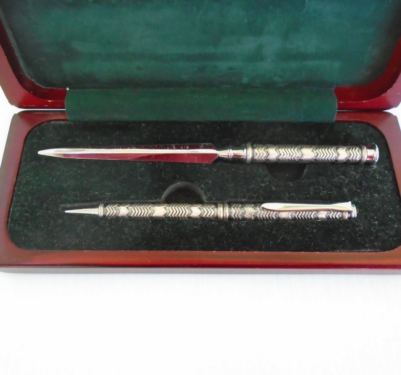 Vintage 1960s desk set consisting of a pen and letter opener, silver in color. Housed in a cherry wood box. Complete set is in excellent condition.