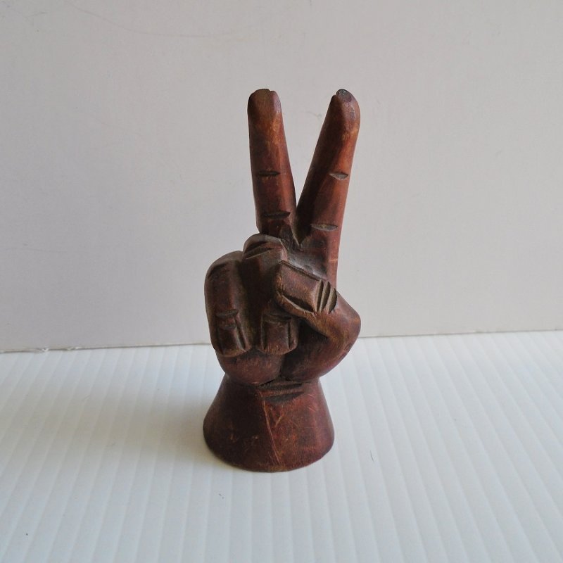 Hand carved peace sign hand. 4.5 inches tall. Dark brown in color. Unknown type of wood. Estate purchase.
