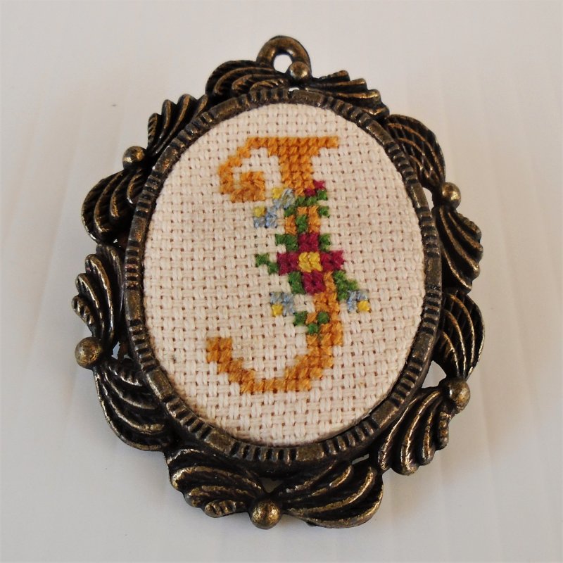 Initial J cross stitch pin brooch. Can also be used as a pendant. Marked Creative Circle on back. 1.75 by 2.25 inch.