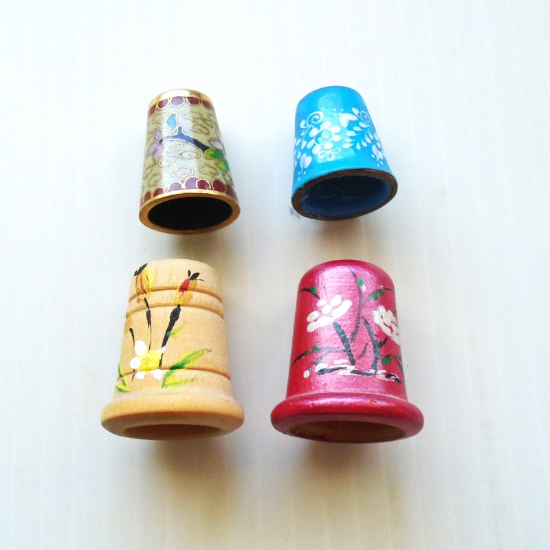 4 Collectible thimbles (2 wood 2 copper) with floral themes. 2 are signed inside.