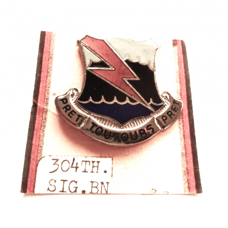 304th Signal Battalion DUI Insignia Pin. It has the motto “Prêt Toujours Prêt” and is from the timeframe of 1960-1965 which was the Vietnam War period.