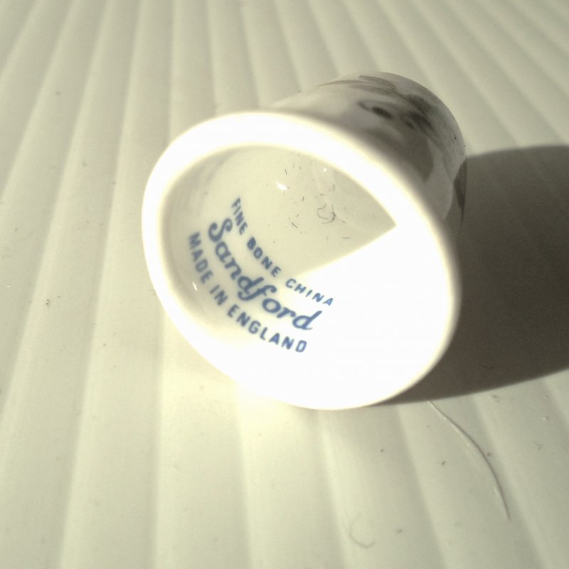 Vintage collectable thimble featuring a blue flower. Made of bone chine. Marked “Sanford, Made in England”.