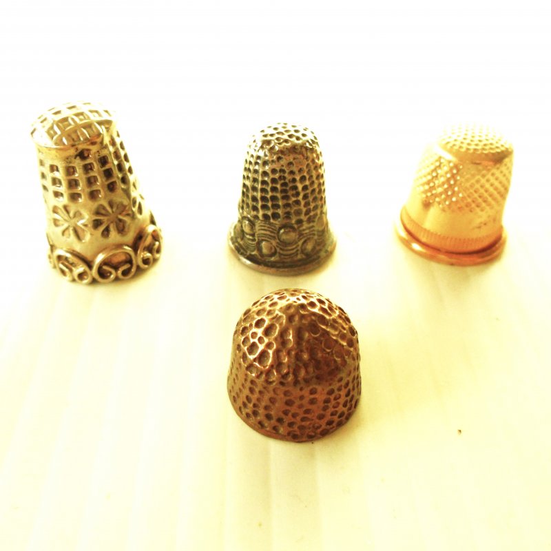 Qty of 4 vintage collectable thimbles. All are metal and measure about 1/2 to just over one inch.