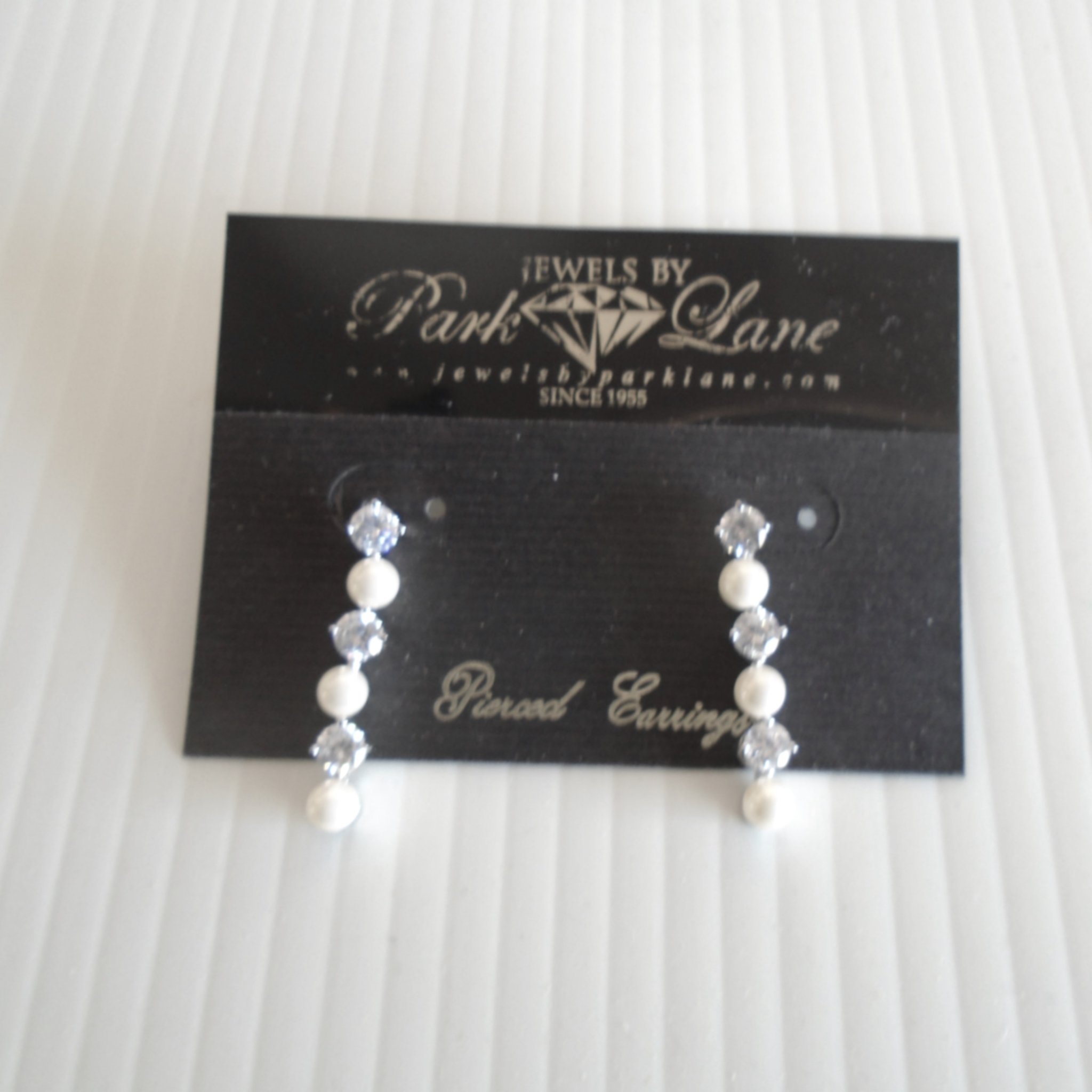 Park Lane Pierced Dangle Earrings. 1.25 inch length with 6 stones that include 3 faux pearls and 3 cubic zirconia stones.