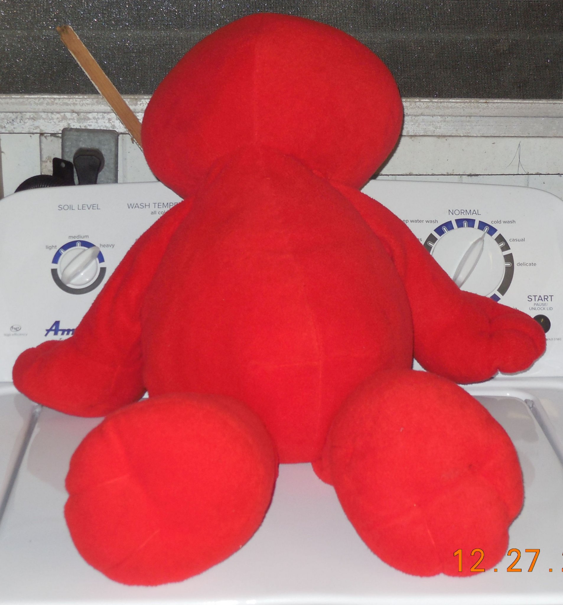 Rear close-up view of the clean red shaggy fur texture on the large Elmo plush doll.