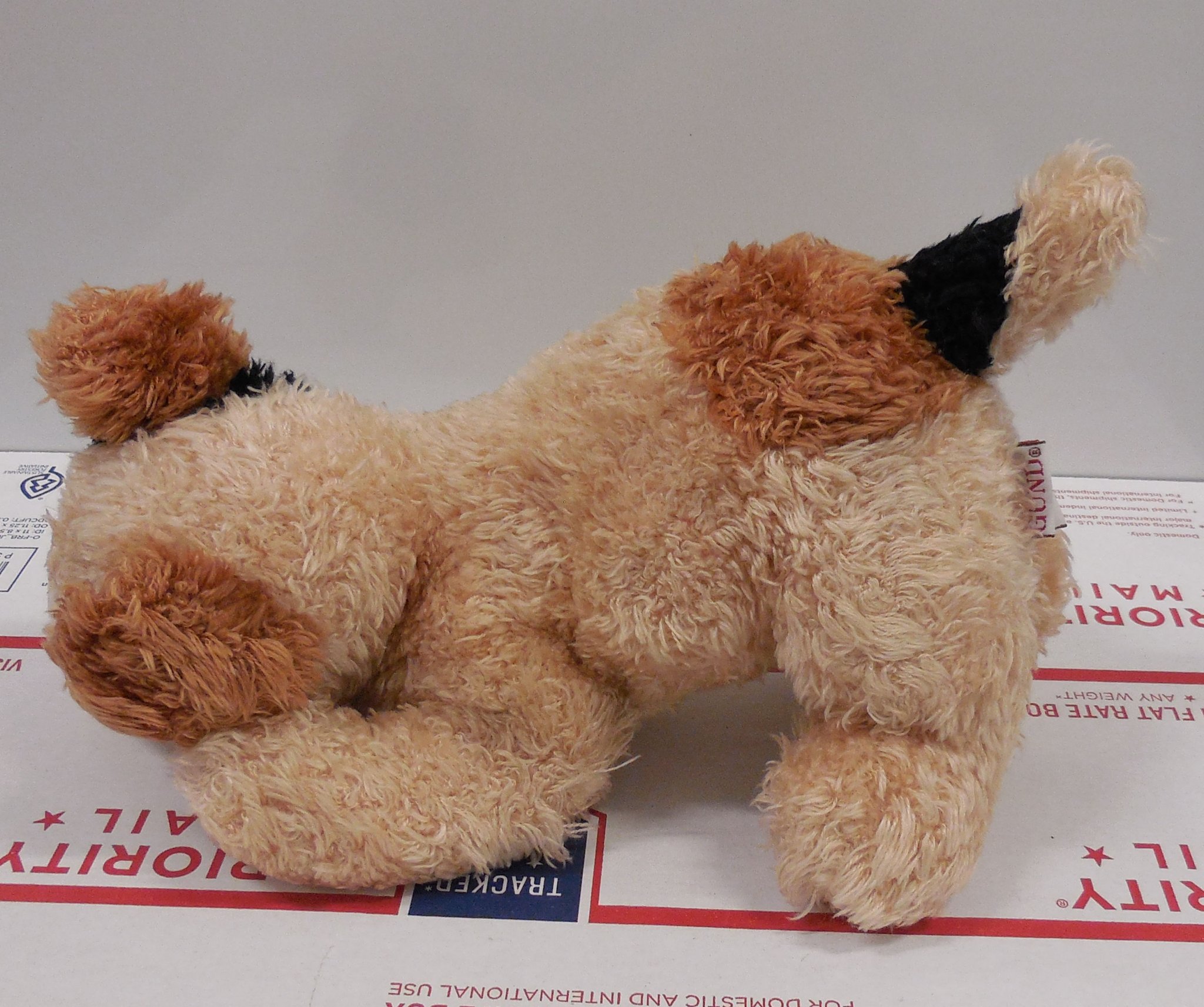Left Side view of the Gund Ketch plush puppy dog highlighting the short brown tail and the position of the cloth tags.