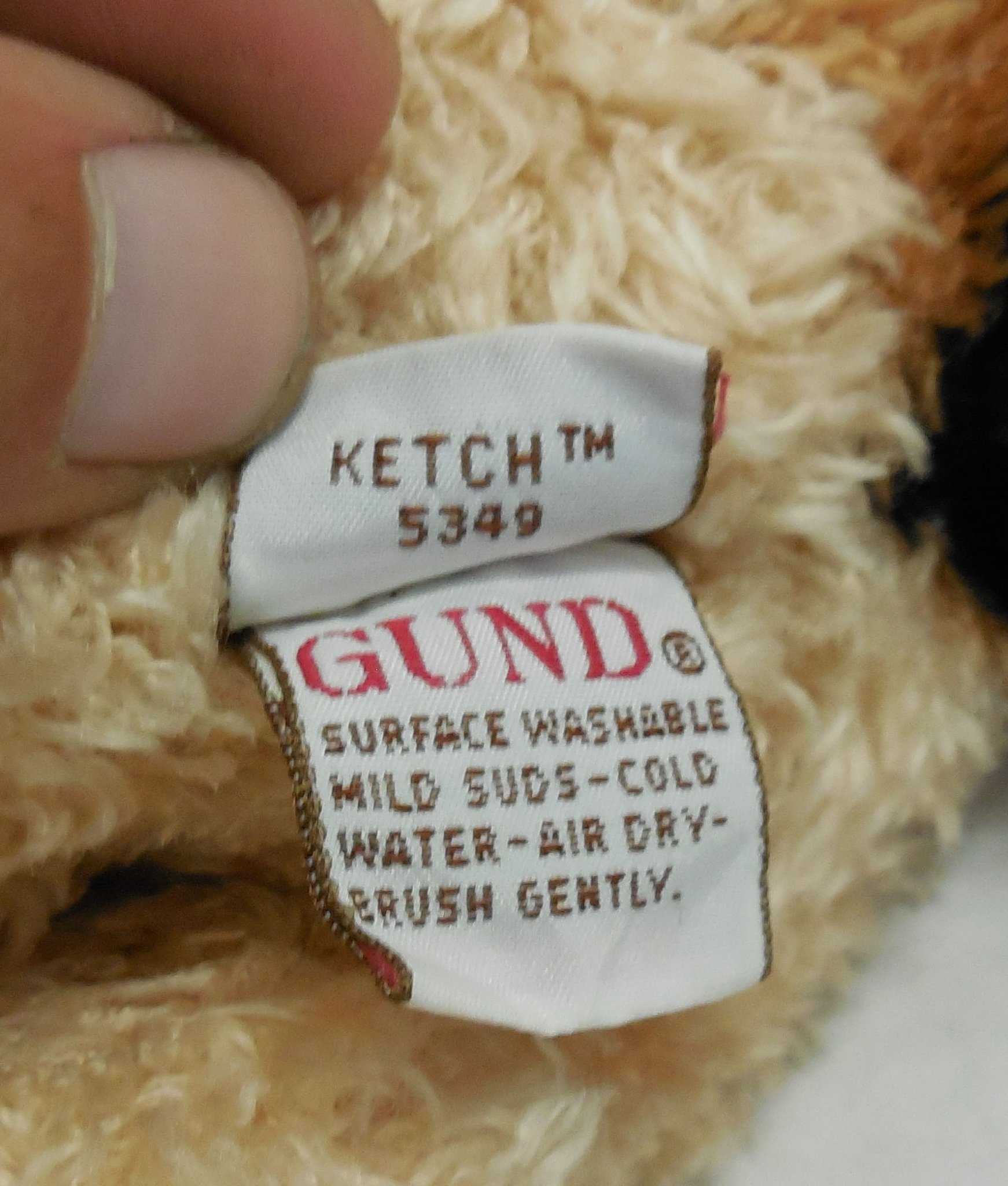 Close-up view of the original white fabric Gund manufacturer tush tag showing registration details and style number 5349.