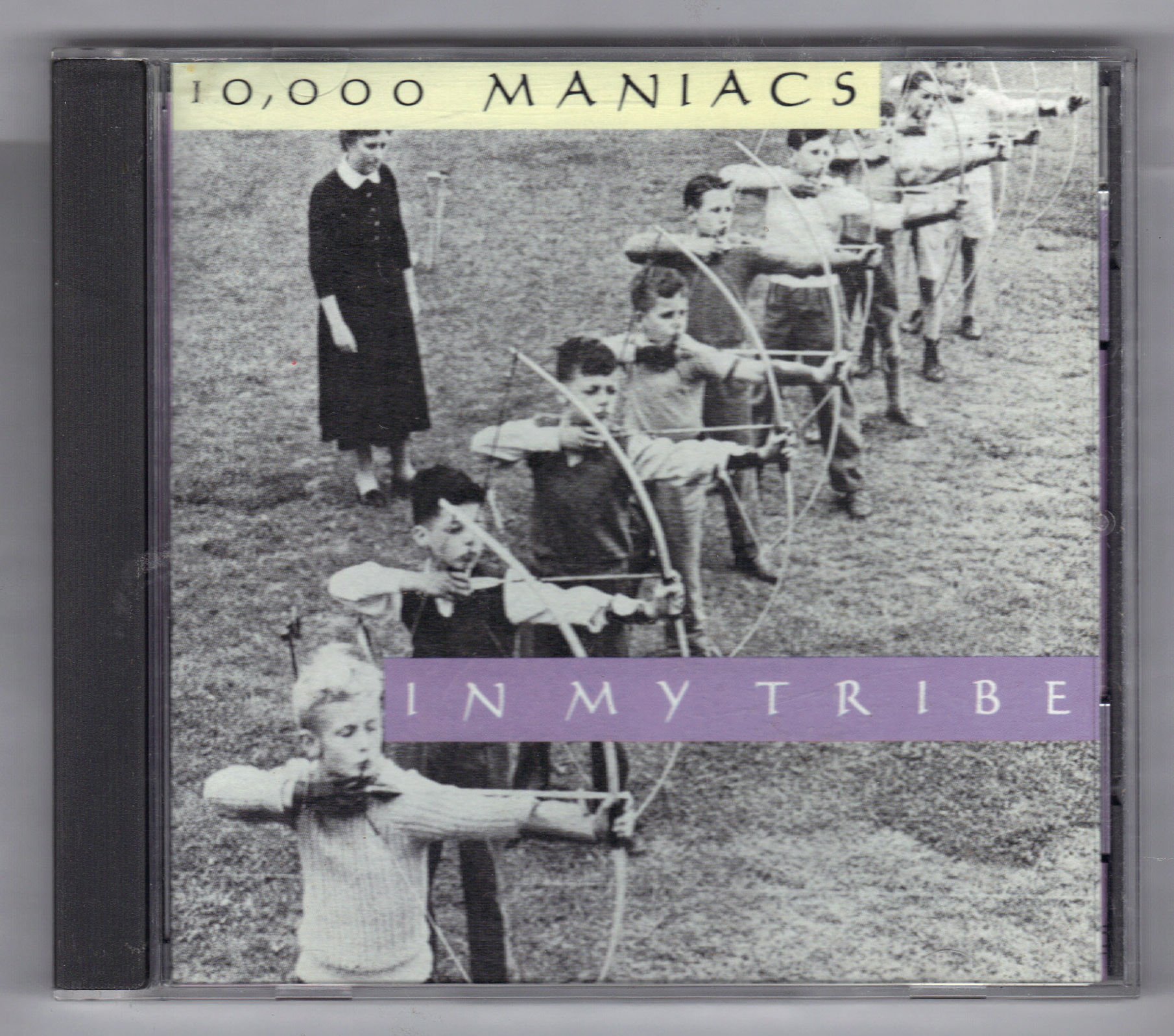 Front cover artwork of the 10,000 Maniacs In My Tribe CD showing the light yellow band title bar over the vintage black and white archery photo.
