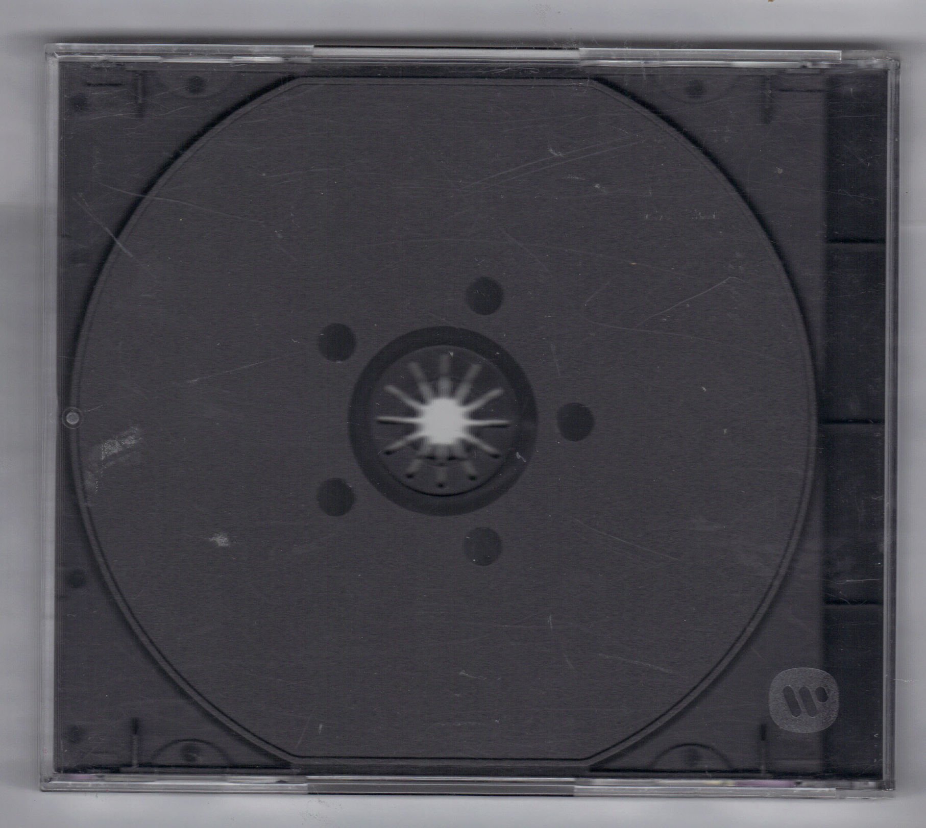 Reverse view of the clear jewel case housing for the 10,000 Maniacs In My Tribe CD showing the grey plastic inner tray and embossed Warner logo.