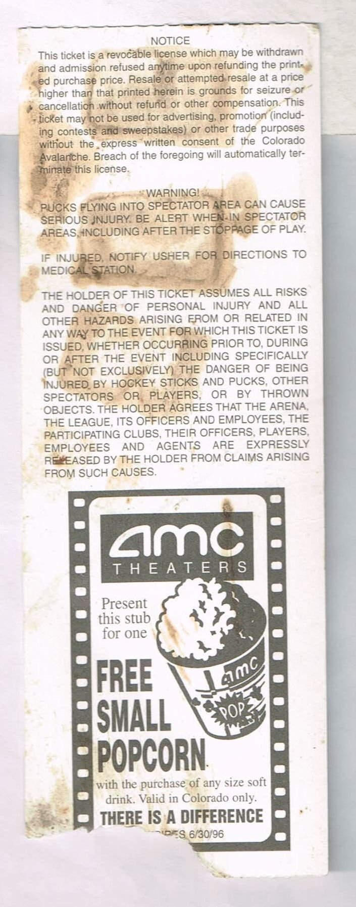 Reverse side of a 1996 Colorado Avalanche hockey playoff ticket stub displaying stadium safety warnings, an AMC Theatres promotion, and vintage water staining.