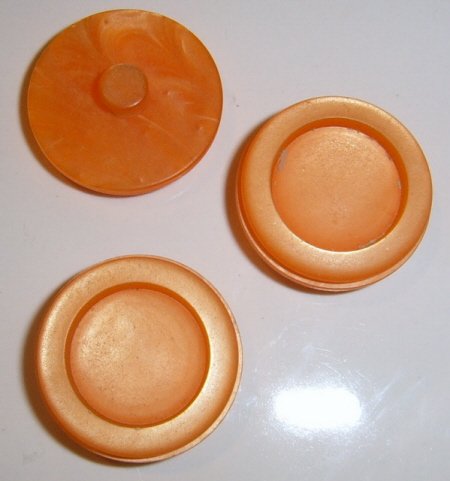 3 Orange plastic buttons