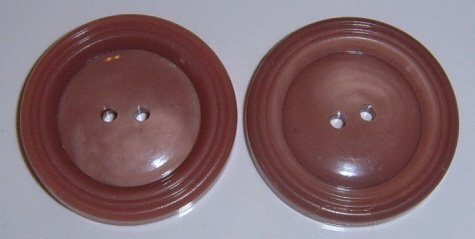 2 light burgundy plastic buttons